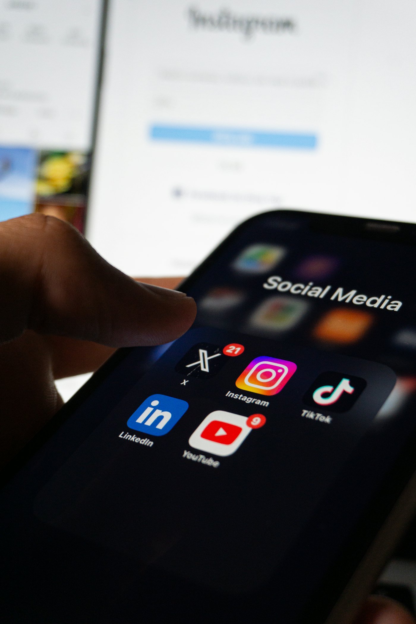 Hand holding a phone showing social media