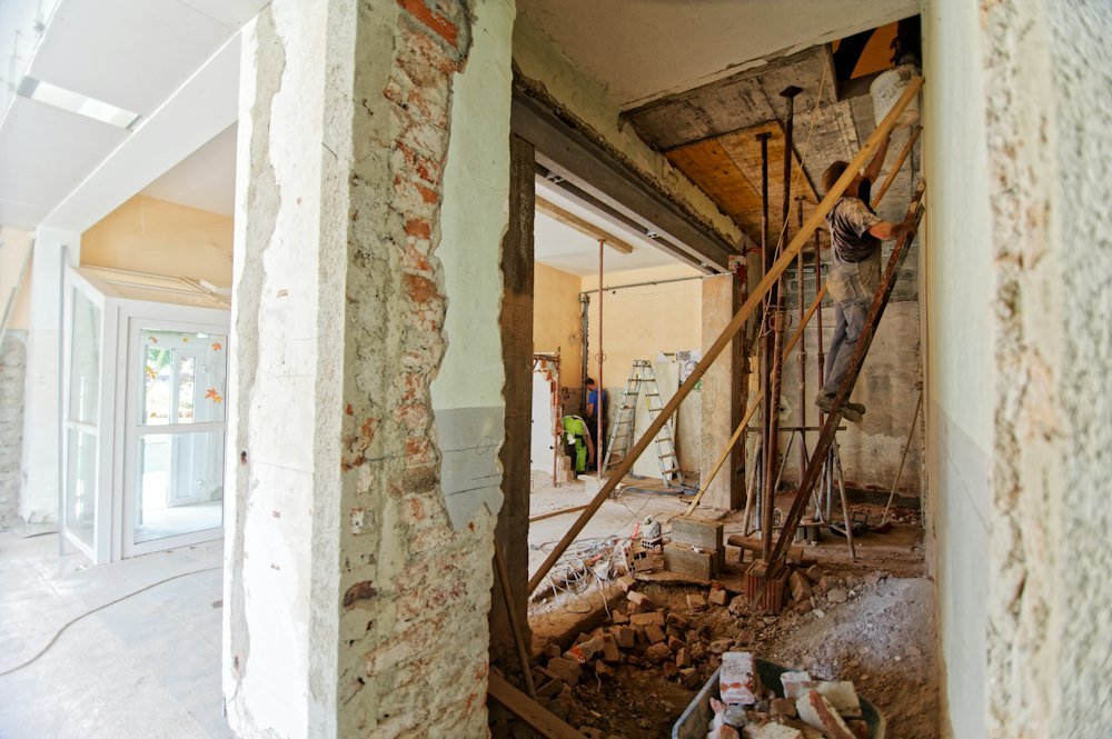 Contractor on a ladder renovating a room