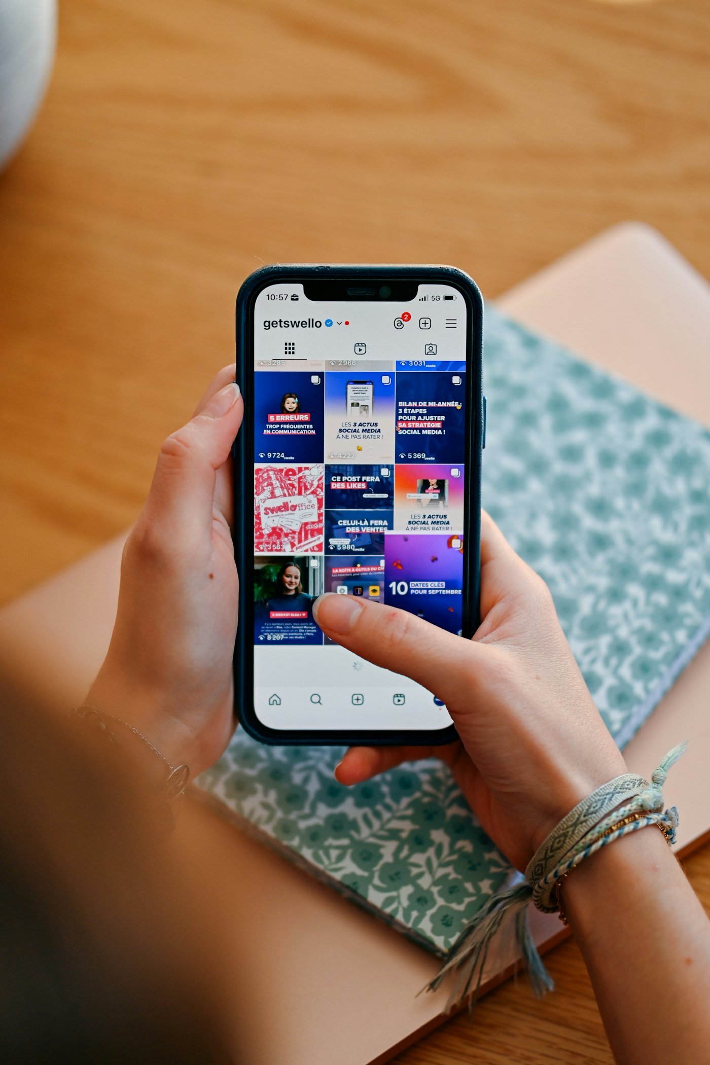 Hands holding a phone with a social media feed